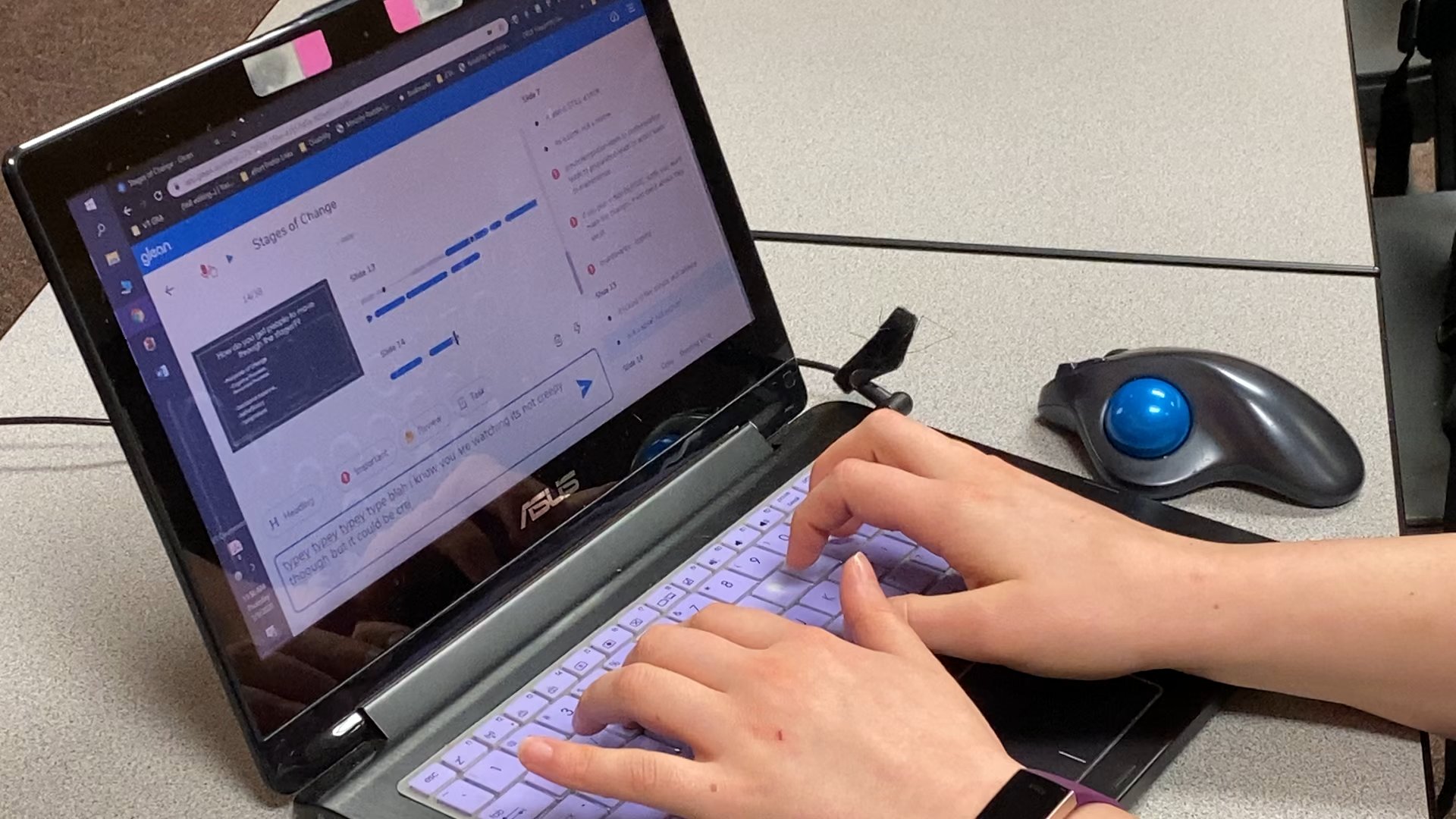 two hands on laptop keyboard. Display shows audio recording and lecture slides.